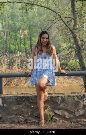 Fröhliche Latina Junge Frau lächelt im Freien mit Selbstvertrauen Stockfoto