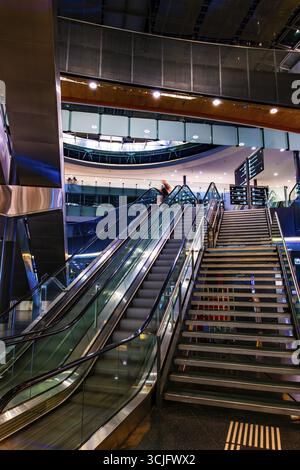 Beleuchteter Flughafen Zürich mit Eskalator in Bewegung bei Nacht im Flughafen Kloten, Zürich, Kanton Zürich, Schweiz Stockfoto