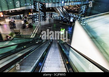 Beleuchteter Flughafen Zürich mit Eskalator in unscharfer Bewegung bei Nacht im Flughafen Kloten, Zürich, Kanton Zürich, Schweiz Stockfoto