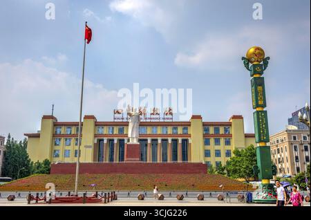 CHENGDU, CHINA - 19. JUNI: Mao Zedong-Statue mit chinesischer Flagge und Menschen, die am Tianfu-Platz in Chengdu, Sichuan, vorbeikommen. Juni 2017 Stockfoto