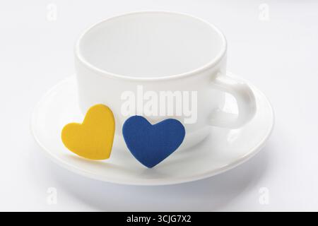 Leere Tasse und Untertasse mit Herzen auf weiß Stockfoto