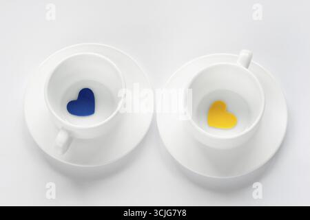 Leere Tasse und Untertasse mit Herzen auf weiß Stockfoto