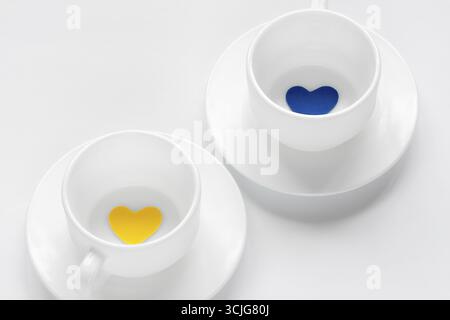 Leere Tasse und Untertasse mit Herzen auf weiß Stockfoto