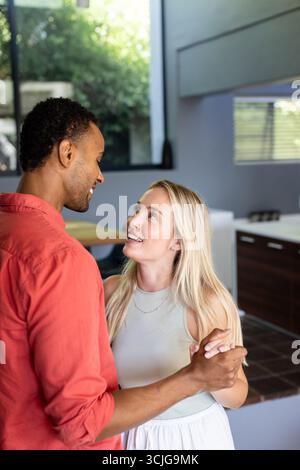 Ein Paar tanzt fröhlich in der modernen Küche und genießt fröhliche Momente zusammen Stockfoto