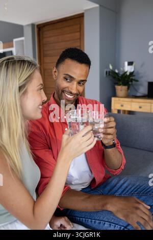 Sie können mit Gläsern Wasser toasten, lächeln und die gemeinsame Zeit zu Hause genießen Stockfoto