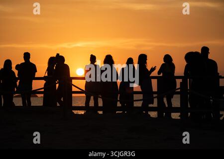 Menschen mit Silhouetten, die den Sonnenuntergang auf Ibiza beobachten Stockfoto