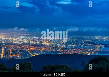 Panoramablick auf da Nang bei Nacht vom Ban Co Peak, mit funkelnden Lichtern der Stadt, Hochhäusern, beleuchteten Brücken über den Han River und Stockfoto