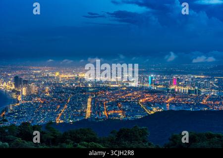 Panoramablick auf da Nang bei Nacht vom Ban Co Peak, mit funkelnden Lichtern der Stadt, Hochhäusern, beleuchteten Brücken über den Han River und Stockfoto