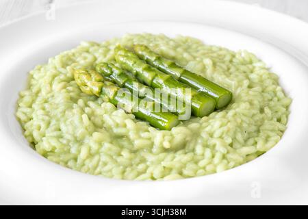 Cremiges Risotto mit grünen Spargelspitzen, garniert und wunderschön präsentiert Stockfoto