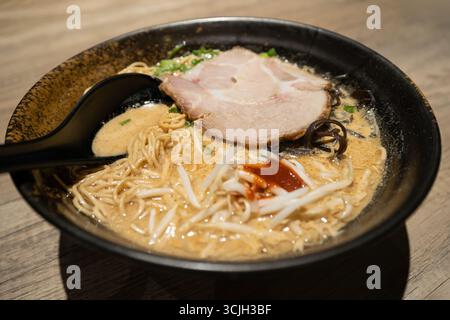 Aus nächster Nähe sehen Sie die japanischen Ramen auf Schweinefrühe, garniert mit langsam gekochtem Charsiu, grünen Zwiebeln, Pilzen und Sprossen. Stockfoto