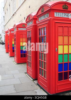 Ikonische rote Telefonboxen mit Pride LGBTQ-Flaggen und -Farben. Covent Garden, London, Großbritannien Stockfoto