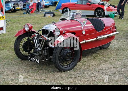 Roter Oldtimer mit drei Rädern bei einer Outdoor-Veranstaltung im Automobilbereich. Shere Hill Climb, East Clandon, Guildford Stockfoto