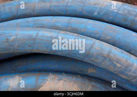 Nahaufnahme des gewundenen blauen Hochleistungsschlauchs im Vollformat, Einsatz in Bohrmaschinen in der Rohrbrunnenindustrie, Soft-Focus-Hintergrund oder -Hintergrund, Industrie Stockfoto