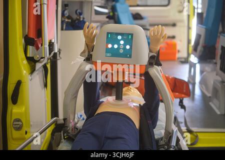 HLW-Trainingspuppe mit automatischem Thoraxkompressionsgerät im Ambulanzwagen zur ärztlichen Notfallausbildung. Stockfoto