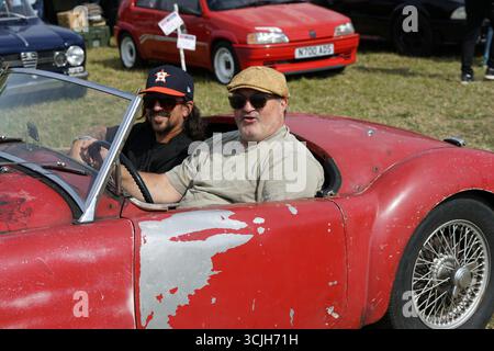 Oldtimer-Fahrt mit zwei lächelnden Freunden bei einem Outdoor-Event. Shere Hill Climb, East Clandon, Guildford Stockfoto