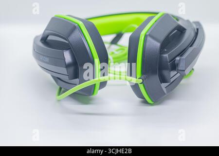 Gaming-Headset in Schwarz und Grün mit kabelgebundener Verbindung auf weißem Studio-Hintergrund. Stockfoto