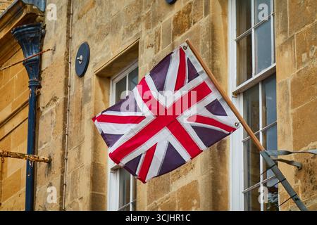 Die britische Jack-Flagge fliegt auf einer historischen Steinmauer Stockfoto
