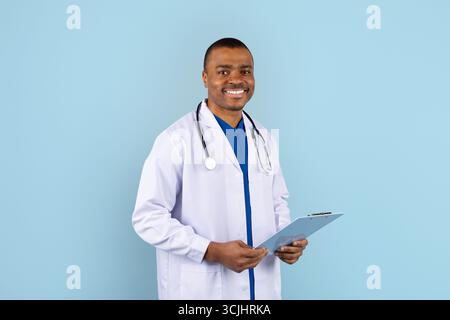 Afroamerikaner Arzt im Atelierporträt lächelnd mit Klemmbrett Stockfoto