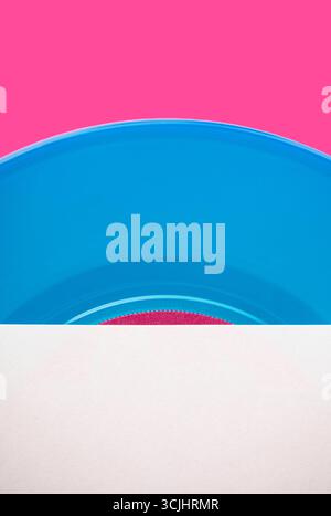 Abstraktes Stillleben einer blauen Schallplatte auf rosa Hintergrund Stockfoto