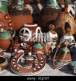 Bunte handgemachte Töpferwaren auf einem Markt. Verschiedene Formen und Größen, einschließlich Töpfe, Figuren und dekorative Gegenstände. Satte Erdtöne und Intr Stockfoto