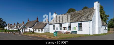 Ein Blick an einem sonnigen Sommertag auf die Hauptstraße des Dorfes Etal in Northumberland bei Berwick, in Richtung des reetgedeckten Pubs The Black Bull Stockfoto