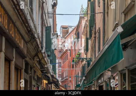Eine enge Straße in Venedig mit den Fassaden alter Gebäude und Rollläden Italien, Venedig, 11. Juli 2025, Stockfoto