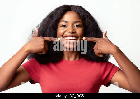 Zahngesundheit. Schöne Junge Afroamerikanische Frau, Die Auf Ihr Lächeln Zeigt Stockfoto