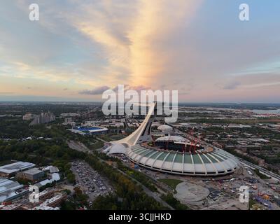 Blick aus der Vogelperspektive auf das Olympiastadion in Montreal bei Sonnenuntergang mit farbenfrohem Himmel und Stadtlandschaft. G. Stockfoto