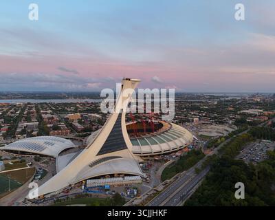 Blick aus der Vogelperspektive auf das Olympiastadion in Montreal bei Sonnenuntergang mit farbenfrohem Himmel und Stadtlandschaft. G. Stockfoto