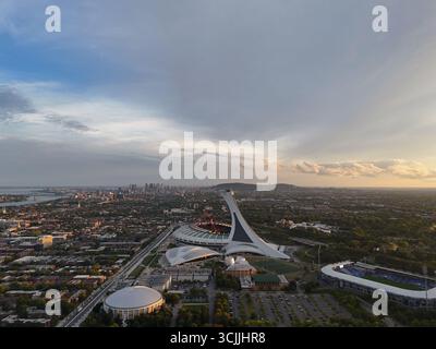 Blick aus der Vogelperspektive auf das Olympiastadion in Montreal bei Sonnenuntergang mit farbenfrohem Himmel und Stadtlandschaft. G. Stockfoto