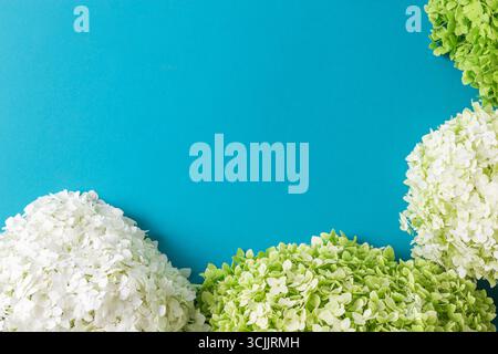 Farbenfrohe Blumenarrangements mit rosafarbenen Alstroemerien, gelben Chrysanthemen und Hortensien auf einem hellblauen Hintergrund. Für Grußkarten, Einladungen, W Stockfoto