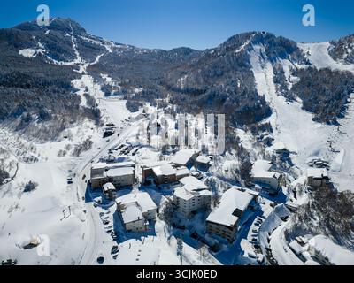 Weite Luftaufnahme eines Skiresorts Dorf und tief verschneite Pisten in Japan. Stockfoto