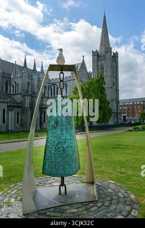 Die Freiheitsglocke, eine Skulptur von Vivienne Roche, auf der eine Möwe thront. St Patricks Park, Dublin, Irland. St. Patrick's Cathedral dahinter. Stockfoto