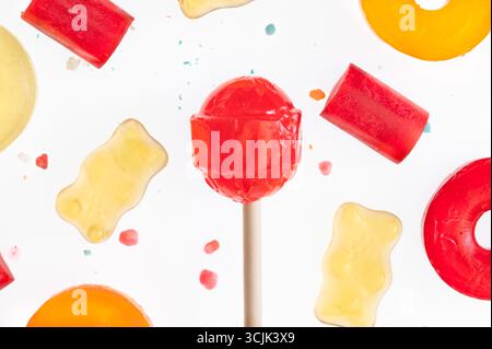 Eine Auswahl an Süßigkeiten, darunter ein Sauger, Gummibären und harte Bonbons, auf weißem Hintergrund Stockfoto