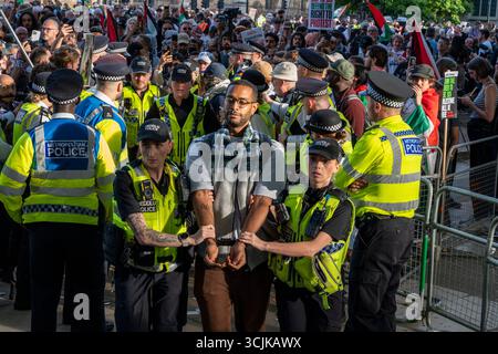 Demonstration der Palästinensischen Aktion 6. September 2025. Ein junger Demonstrant in Handschellen, weil er ein Plakat mit der Aufschrift „Ich unterstütze die Palästinensische Aktion“ gehalten hat, wird von der Polizei weggeführt. Stockfoto
