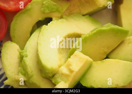 Frische Avocadoscheiben auf einem bunten Teller Stockfoto