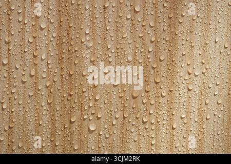 Wassertropfen bilden ein natürliches Muster auf Holz Stockfoto