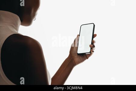 Nahaufnahme einer Person, die ein Smartphone mit leerem Bildschirm hält, isoliert auf weißem Hintergrund. Perfekt für Mockups für mobile Apps, Technologiekonzepte und Pendlerverkehr Stockfoto