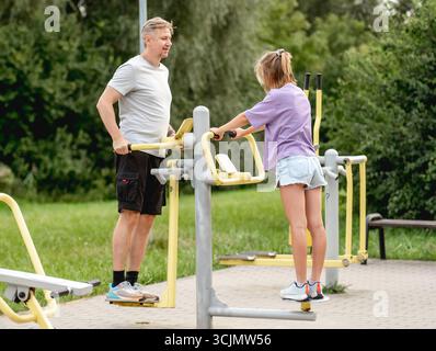 Vater Und Tochter Trainieren Gemeinsam Auf Dem Spielplatz, Bonding Durch Outdoor-Aktivitäten Stockfoto
