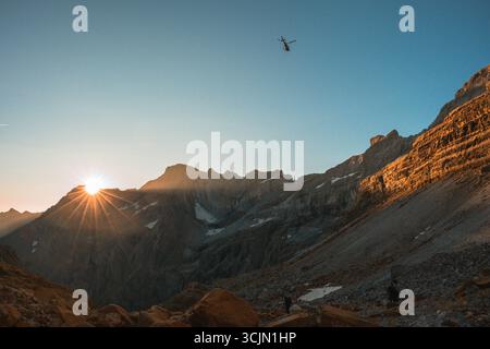 Ein Rettungshubschrauber, der während des Sonnenaufgangs über die Pyrenäen fliegt Stockfoto