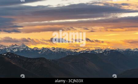 Majestätische Bergkette unter einem lebendigen Sonnenuntergang Stockfoto