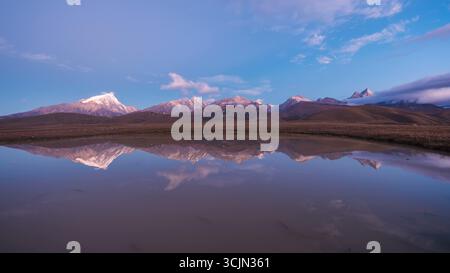 Bergreflexionen in einem stillen Gewässer in der Abenddämmerung Stockfoto