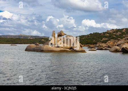Kuriose Felsformationen erheben sich aus klarem Wasser in der Nähe von üppigen Hügeln auf der Insel La Testa del Polpo, La Maddalena Archipel, Sardinien. Stockfoto