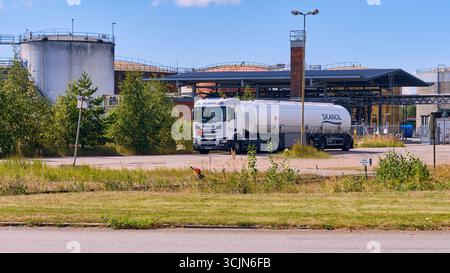 Halmstad, Schweden; 25. August 2023: Tankwagen Skanol verlässt die Öllagerstätte mit großen Tanks im Hintergrund. Stockfoto