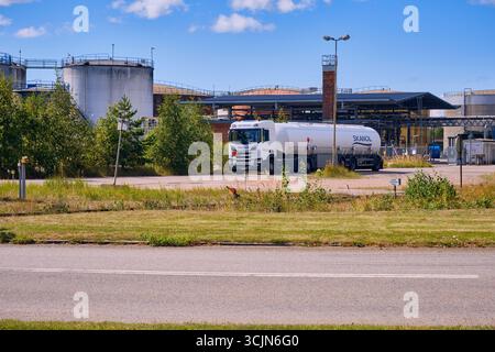 Halmstad, Schweden; 25. August 2023: Tankwagen Skanol verlässt die Öllagerstätte mit großen Tanks im Hintergrund. Stockfoto