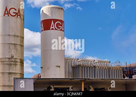 Halmstad, Schweden; 25. August 2023: AGA-Hochdruckgasflaschen in Industrieanlagen mit sichtbaren Rohren im Hintergrund. Stockfoto