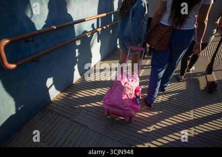 Madrid, Spanien. September 2025. Ein Mädchen zieht ihren Rucksack, als sie an ihrem ersten Schultag in die Schule geht. In der Gemeinde Madrid beginnt das Schuljahr 2025/2026 für Vorschulen, Grundschulen, Sonderschulen und private Vorschulen. Quelle: SOPA Images Limited/Alamy Live News Stockfoto