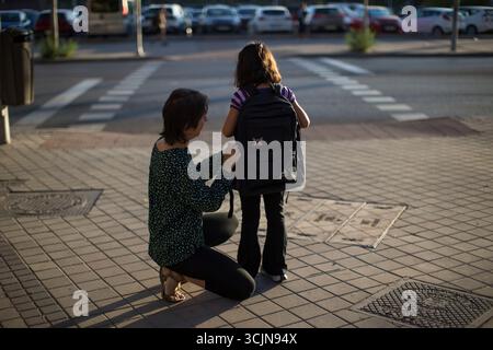 Madrid, Spanien. September 2025. Eine Mutter repariert den Rucksack ihrer Tochter auf dem Weg zur Schule und begleitet sie am ersten Schultag. In der Gemeinde Madrid beginnt das Schuljahr 2025/2026 für Vorschulen, Grundschulen, Sonderschulen und private Vorschulen. Quelle: SOPA Images Limited/Alamy Live News Stockfoto