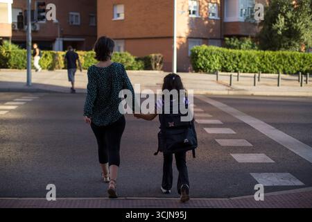 Madrid, Spanien. September 2025. Ein Mädchen mit dem Rucksack und der Hand ihrer Mutter überquert am ersten Tag des Schuljahres eine Ampel auf dem Weg zur Schule. In der Gemeinde Madrid beginnt das Schuljahr 2025/2026 für Vorschulen, Grundschulen, Sonderschulen und private Vorschulen. Quelle: SOPA Images Limited/Alamy Live News Stockfoto