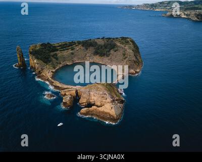 Ein Blick aus der Vogelperspektive auf die Insel Vila Franca do Campo auf den Azoren mit ihrer kreisförmigen Lagune umgeben von vulkanischen Klippen und dem tiefblauen Atla Stockfoto